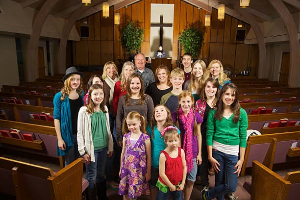 Multigenerational church group standing in pews